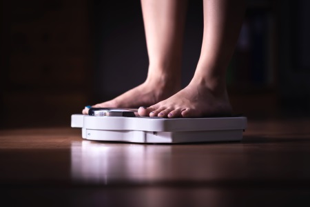 Woman standing on weighing scales