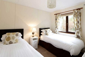 Twin bedroom of one of our Argyll Chalets with large window to view surrounding area