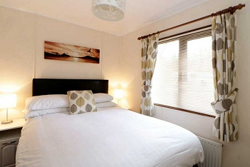 Master bedroom of on of our Argyll Chalets, with large window for viewing the surrounding vistas