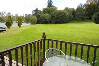 A view from the porch of an Argyll chalet, looking over surrounding trees and loch