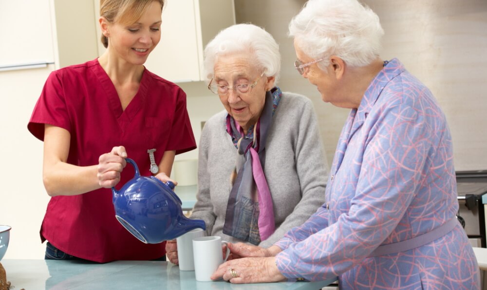 Carer helping to elderly women