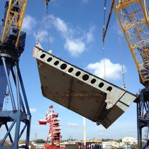 Cranes lifting section of bridge