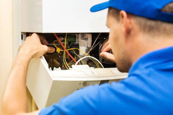 Maintenance service engineer working with home gas heating boiler