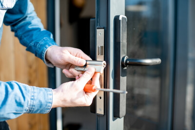 man holding key core of door lock