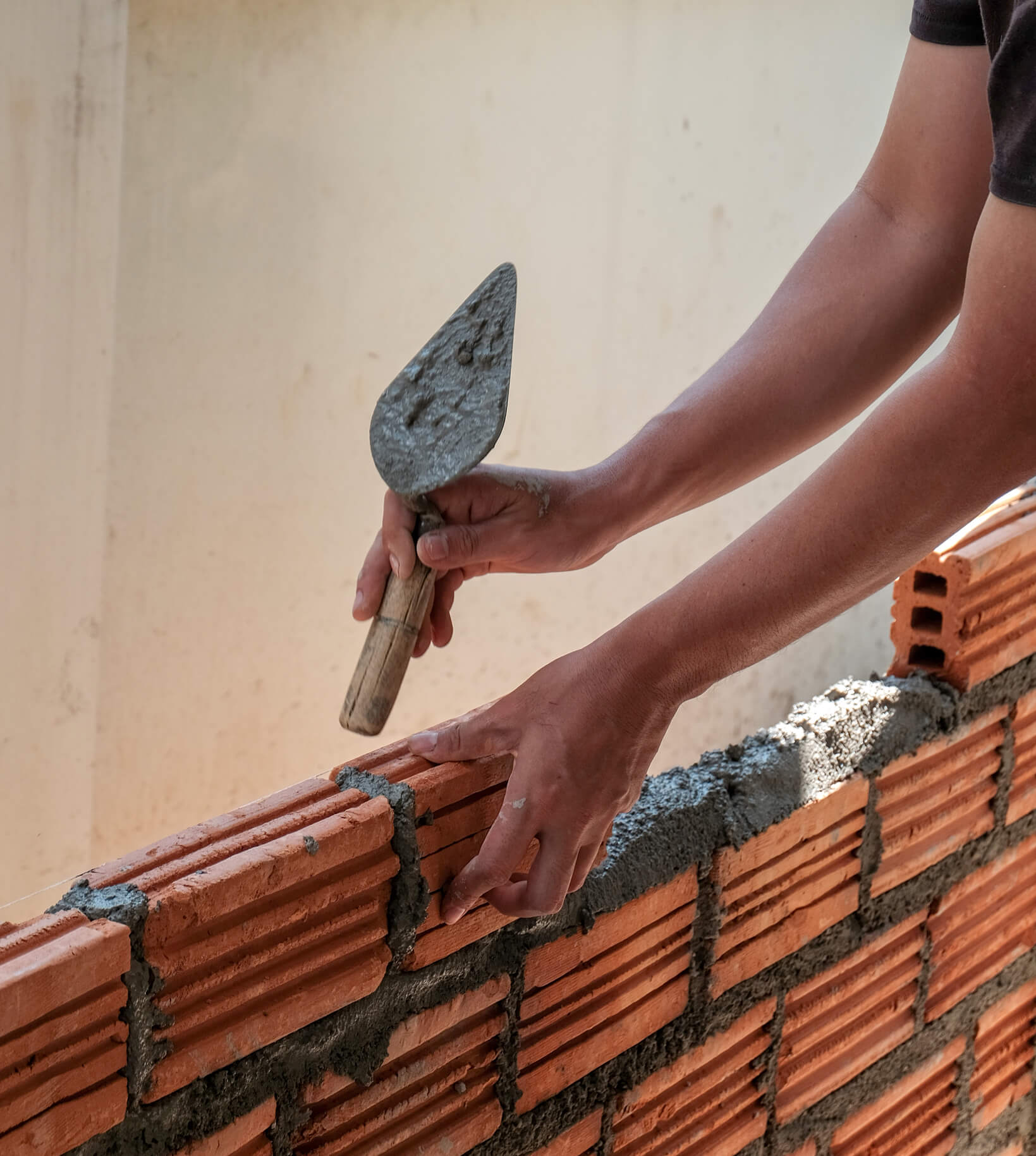 Builder laying bricks with a trowel