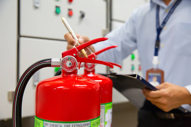 Inspector signing off on Fire Extinguishers
