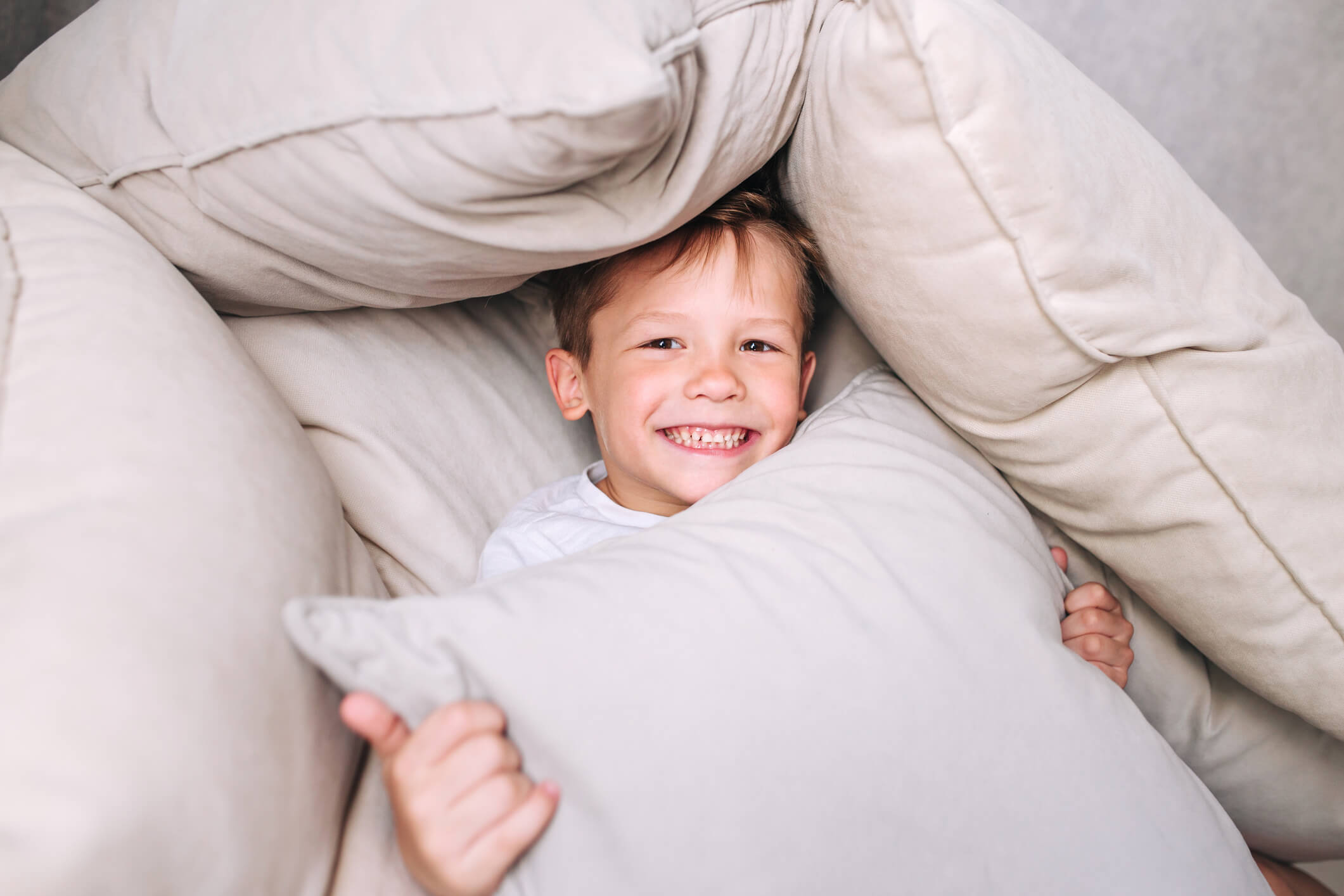 child hiding in a pillow den