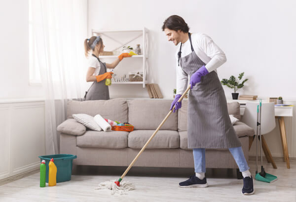 Two cleaners cleaning a living space in an apartment