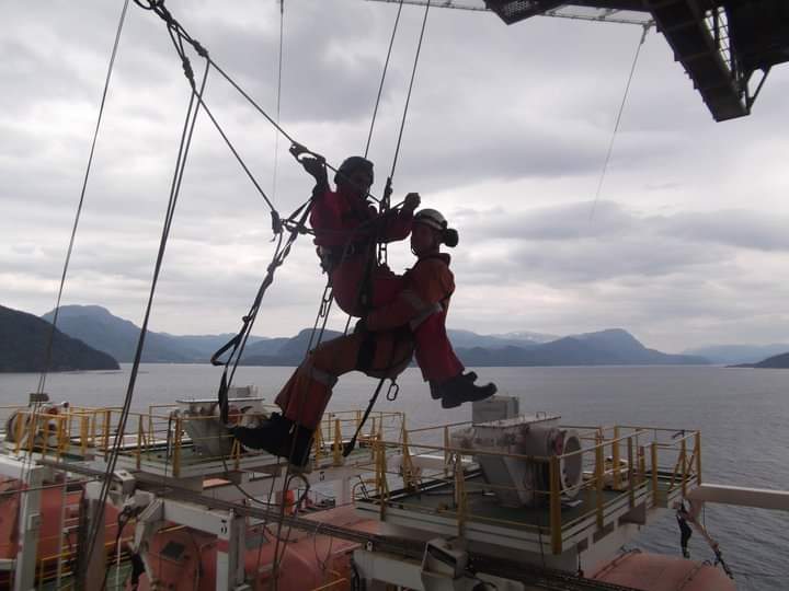 Two Men attached to Metal Rig