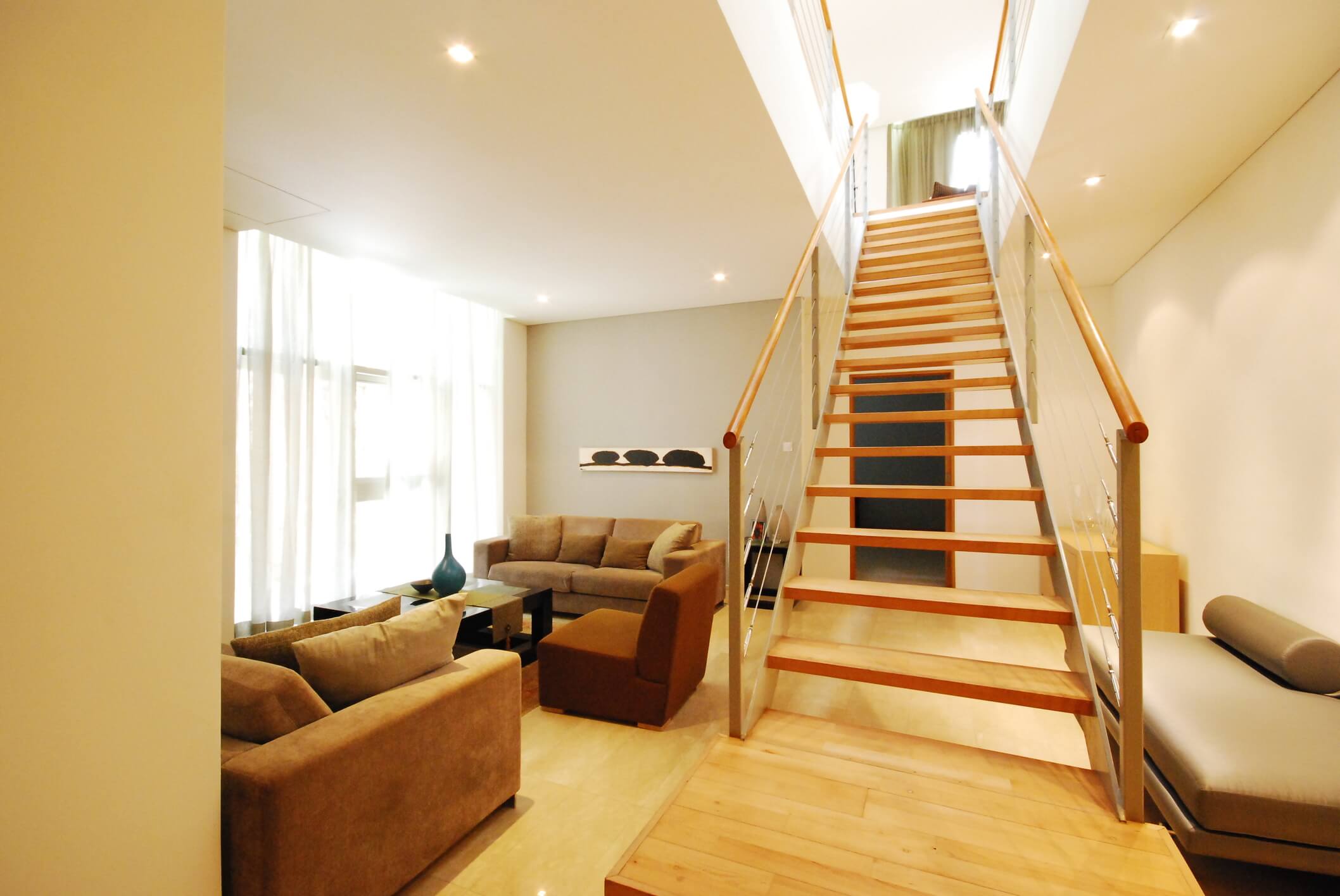 Modern living room basement conversion, with staircase leading upstairs