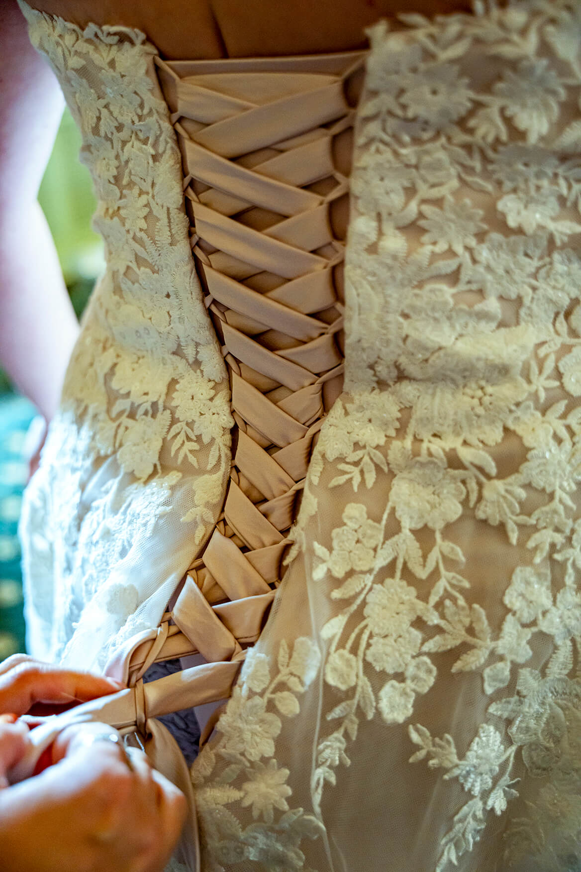 Close up of back of wedding dress as it is being fastened up