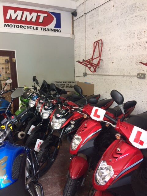 Scooters and other motorcycles parked next to each other.