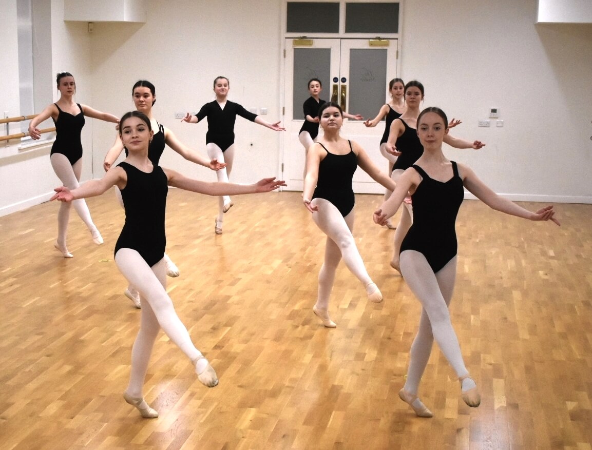 Row of ballerinas in pointe shoes