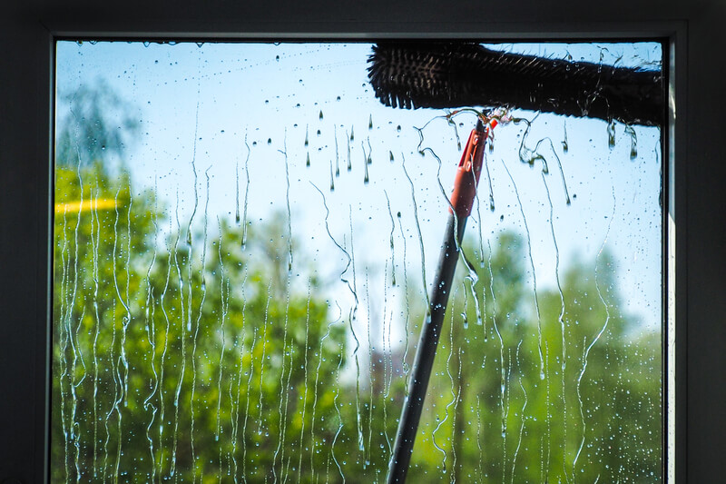 Window cleaning using telescopic water brush and wash system.