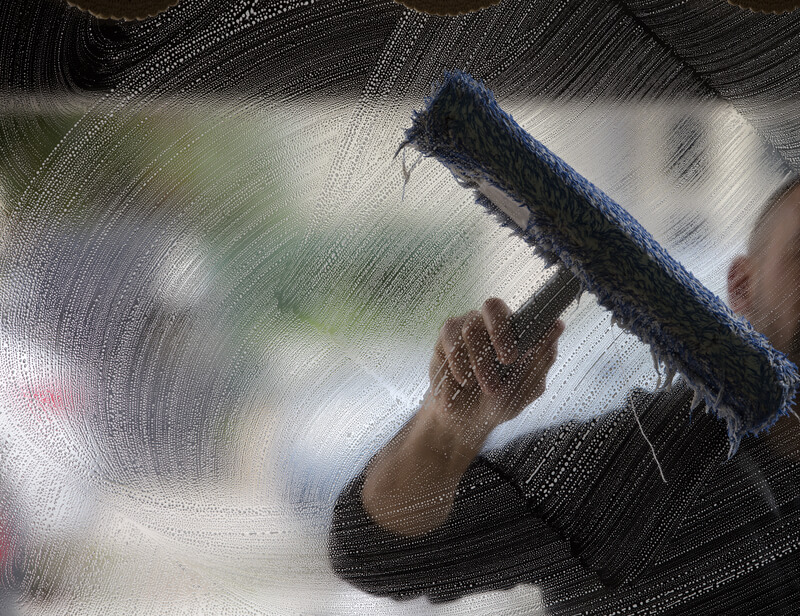 A soapy window with a squeegee cleaning the glass