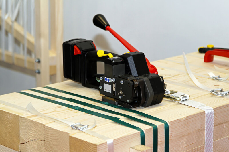 Portable strapping machine for packing crates and boxes