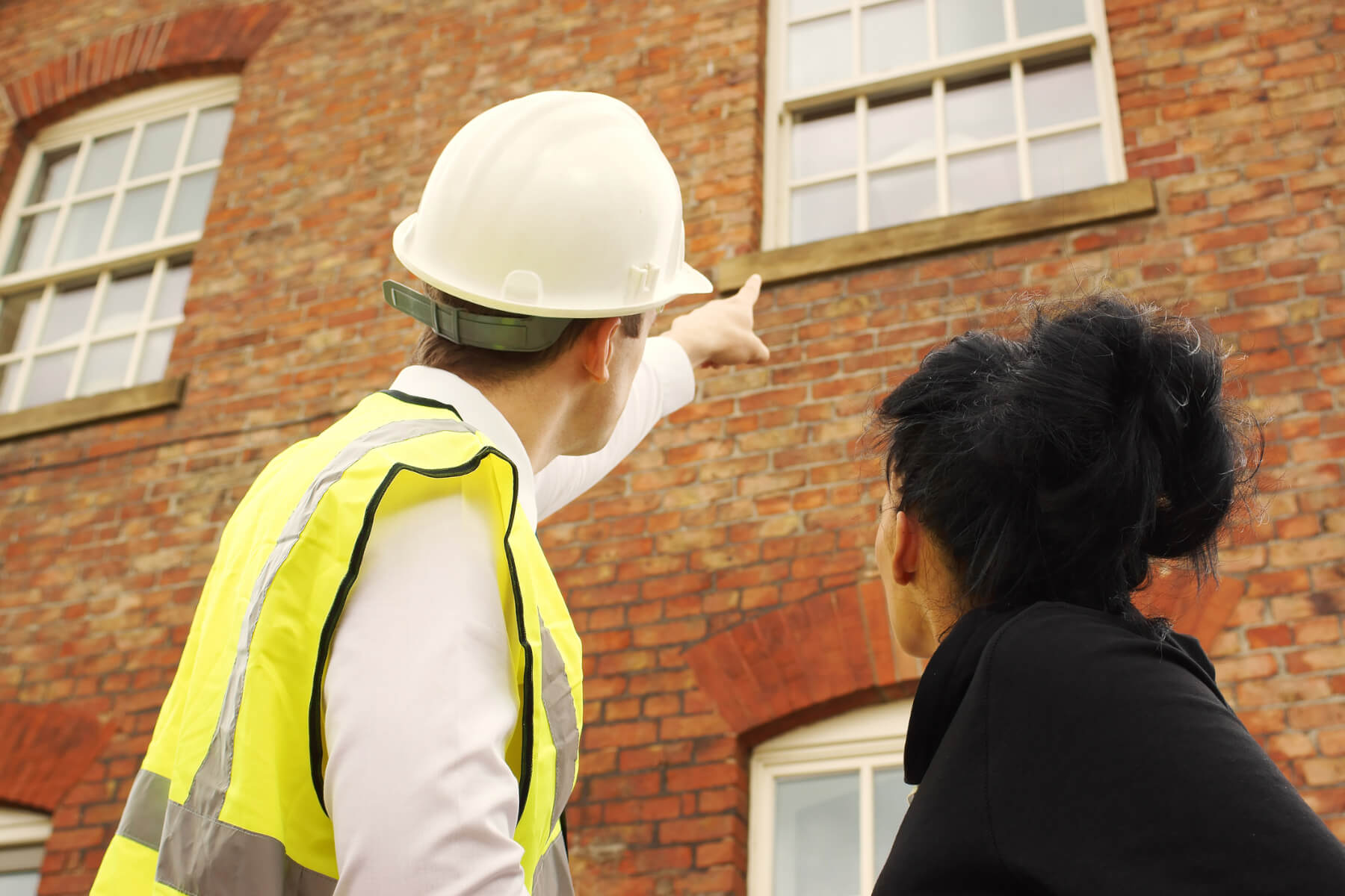 Surveyor builder homeowner looking at property.