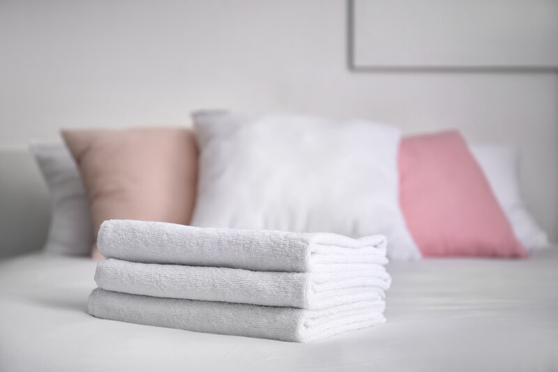 Hotel Room with neatly folded bedding and towels