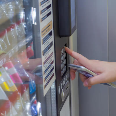 Person using vending machine to buy a drink