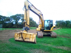 This is a second picture of our excavator but showing it with a large blade attachment (home made). Mainly used for stripping and re-spreading large areas of topsoil increasing speed and productivity when used instead of a bucket.