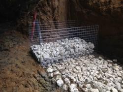 With the earth excavated we now start to install the gabions onto a bed of rock so that they cannot slide  