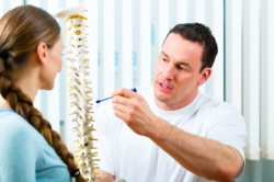 Physiotherapist explaining treatment for spine related problems.