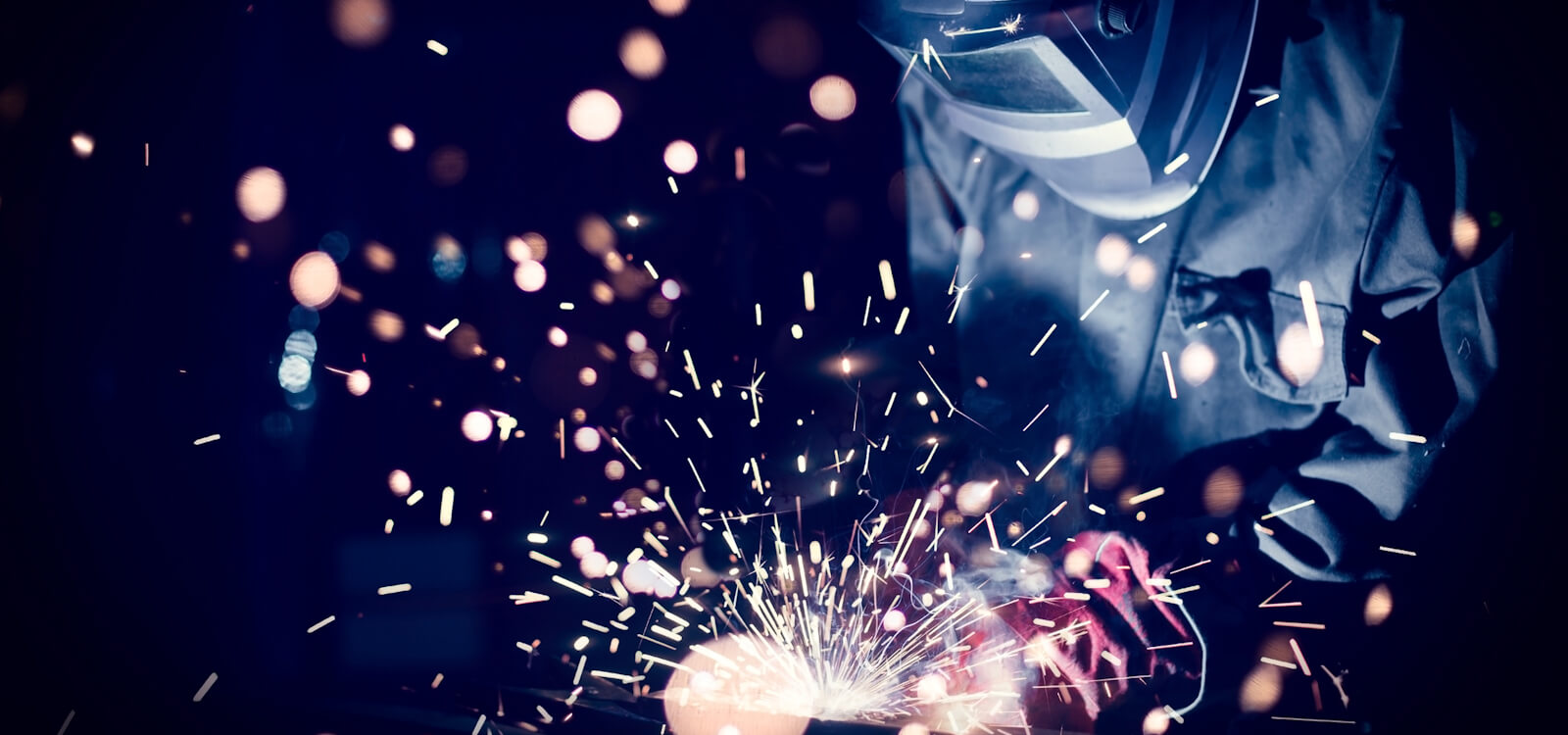 Worker welding steel with sparks using mig mag welder