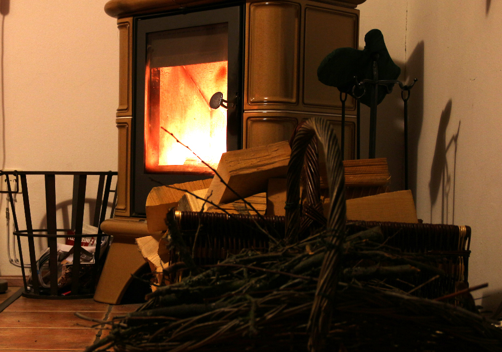 Lit wood burning stove and wicker basket